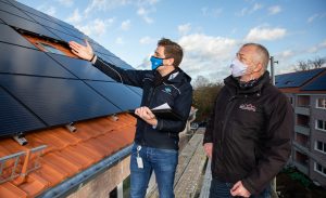 Bevor das Baugerüst entfernt wird, schauten sich Frederik Stroetmann (Stadtwerke Münster) und Andreas Jenschke (Wohn + Stadtbau) die neuen Photovoltaik-Anlagen an der Von-Stauffenberg-Straße noch einmal aus der Nähe an.