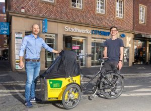 Das kostenlose Lastenrad Lotte kann bis Ende Juli im CityShop der Stadtwerke ausgeliehen werden. Darüber freuen sich Steffen Schmidt von der Lastenrad-Initiative „Lasse“ (r.) und CityShop-Leiter Marcel Braulik. (Foto: Stadtwerke)