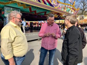 Weihbischof Zekorn (re.) auf dem Send im Gespräch mit Schausteller Hans-Kurt Wimmer, mit dabei Stefan Rosenboom (li.) vom Schaustellverband. (Foto: Bischöfliche Pressestelle/Ann-Christin Ladermann)