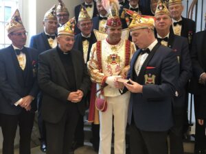 Als ein Zeichen, dass die Tür für die Menschen immer offen steht, überreicht Generalprinzmarschall Paul Middendorf (r.) unter den Augen von Stadtprinz Mario I. Engbers einen Türkeil an Münsters Bischof Felix Genn (l.). (Foto: Bischöfliche Pressestelle, Jule Geppert)