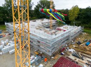 Der Rohbau ist fertig: Ein bunter Richtkranz schmückt die neue Grundschule in Sprakel. (Foto: Stadt Münster / Münsterview)