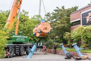 Mittels eines Krans wurde die Station vom Anhänger des LKWs zu den bereits platzierten Füßen der Station geschwenkt. (Foto: LWL / Steinweg)