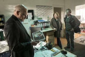 Wilsberg (Leonard Lansink, li.) findet im Büro des zweiten Opfers ein interessantes Foto. Kommissarin Anna Springer (Rita Russek) und Overbeck (Roland Jankowsky) sind von der Einmischung des Privatdetektivs wenig begeistert. (Foto: ZDF / Thomas Kost)