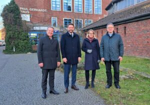 Die Projektpartner trafen sich vor Ort am künftigen Standort des Bildungs- und Begegnungs-Campus in Münster (v.l.): Dr. Nils Brüggemann, Stadtbaurat Robin Denstorff, Annika Wolter und Pfarrer Frank Winkelmeyer. (Foto: St. Franziskus-Stiftung Münster)