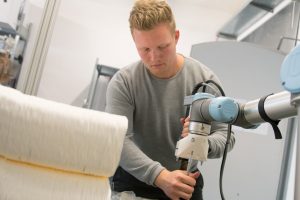 Moritz Wesseler stattet den Roboterarm mit einem Extruder aus. (Foto: FH Münster/Pressestelle)