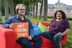 Ein knallrotes Sofa inmitten der Stadt – das ist das Symbol mehrerer Initiativen für mehr Wohnraum in Münster. Tim Osterhaus, ehemaliger Referent des AStA der WWU, ist Initiator der Aktion „Rotes Sofa“, die auch Roxana Raphael-Kuttig, AStA-Vorsitzende der FH Münster, tatkräftig unterstützt. (Foto: FH Münster/Pressestelle)