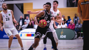 Power Forwad Malcolm Delpeche (22, WWU Baskets Münster) in der Partie bei den ART Giants Düsseldorf (22, Alexander Möller, rechts Dainius Zvinklys) (Foto: Christina Pohler)