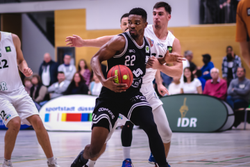 Power Forwad Malcolm Delpeche (22, WWU Baskets Münster) in der Partie bei den ART Giants Düsseldorf (22, Alexander Möller, rechts Dainius Zvinklys) (Foto: Christina Pohler)