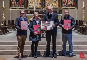 (v.l.:) Martin Lohoff, Lisa Brößkamp und Thomas M. Weber übergeben Dompropst Kurt Schulte (2.v.r.) den neuen Bildband „Kirchen mitten in Münster  –  Wo Geschichte, Kunst und Glaube sich begegnen“. (Foto: wf / Weber)