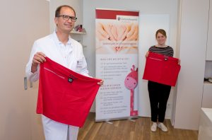 Chefarzt Dr. Rüdiger Langenberg (l.) und Sabrina Schulz vom Fundraising mit zwei Exemplaren der neuen Bonding-Tops des Clemenshospitals. (Foto: Alexianer Misericordia GmbH)