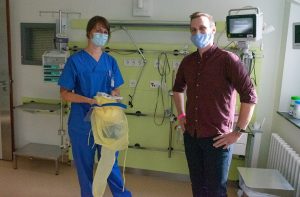 Carla Mefus (l.) zeigt Florian Janssen die Schutzkleidung, die alle Mitarbeiter der Intensivstation tragen müssen, wenn sie das Zimmer eines Corona-Patienten betreten. (Foto: Clemenshospital / Michael Bührke)