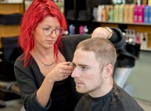 Jonathan Kuban von den „Münster Mammuts“ lässt sich von Katrin Maasjost die Haare schneiden. (Foto: Clemenshospital)