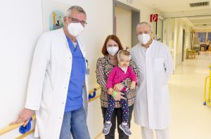 Die kleine Anna und ihre Mutter Svetlana Butning (m.) freuen sich mit Dr. Bernd Hoffmann (l.) und Prof. Dr. Dr. Ulrich Meyer (r.) über die erfolgreiche Operation. (Foto: Michael Bührke)