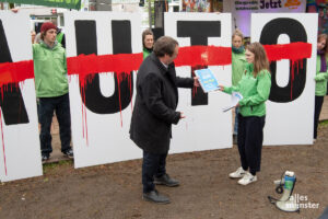 Greenpeace-Sprecherin Clara Thompson übergibt die 49.000 Unterschriften starke Petition am Rande der Verkehrsministerkonferenz an Nordrhein-Westfalens Verkehrsminister Oliver Krischer. (Foto: Michael Bührke)