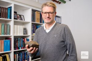 Prof. Dr. Thorsten Kleine mit einem Meteoriten, ein Abschiedsgeschenk von einem langjährigen Mitarbeiter. (Foto: Bührke)