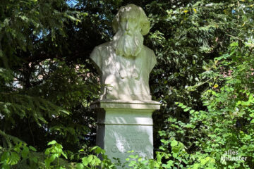 Steht nicht nur während der Grünflächenunterhaltung an der Promenade: Die Statue von Julius Otto Grimm. (Foto: Bührke)