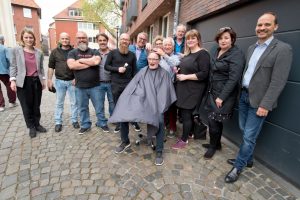 Für das Foto ausnahmsweise auf der Straße vor dem Treffpunkt, normalerweise in dessen geschützten Räumen: Münsters Friseure schneiden Menschen in sozialen Notlagen kostenlos die Haare. (Foto: Pressefoto)