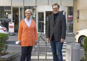 Der Comedian Jens Heinrich Claassen (r.) und die Vorsitzende des Fördervereins Palliativmedizin Raphaelsklinik, Gaby Marbach (l.) während der Spendenübergabe. (Foto: Bührke/Raphaelsklink)