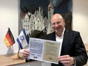 Oberbürgermeister Markus Lewe präsentiert die Urkunde, mit der die Partnerschaft zwischen Rishon LeZion und Münster vor genau 40 Jahren besiegelt wurde. (Foto: Stadt Münster)