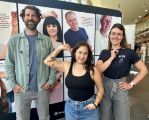 Die Medizinische Fachangestellte Janina Reina Miranda (Mitte) zeigt mit dem neuen Tattoo ihre Bereitschaft zur Organspende. Martin Rieck, transplantationsbeauftragter Arzt des St. Franziskus-Hospitals und Lena Westermann (Junge Helden) freuen sich über die gelungene Aktion. (Foto: St. Franziskus Hospital)