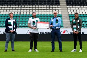 Martin Rademaker (Fiege Vorstand), Christian Schliephorst (Fußballfans gegen Krebs), Jan Schneider (1. Vorsitzender Kinderkrebshilfe Münster) und Preußenspieler Nicolai Remberg (v.l.) bei der Spendenübergabe. (Foto: MS/SC Preußen Münster)