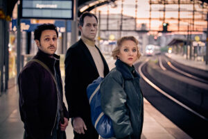 Dimitrij Schaad, Marc Hosemann und Anna Maria Mühe (v.l.) warten auf den Zug. (Foto: Stephan Rabold)