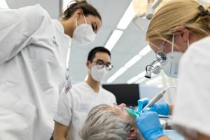 Der betreuende Zahnarzt Dr. Nico Peter Schwarzbach gibt den Studierenden Amelie Zipser und Nick Paßlack sowie dem „Klinik-Profi“ Dieter Eich Tipps für das Einsetzen der neuen „Dritten“ (Foto: WWU / P. Leßmann)