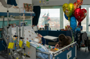 Willkommene Überraschung im Krankenhausalltag: Der fünfjährige Leon winkt aus dem Bett heraus Spiderman am Fenster zu. (Foto: UKM)