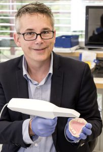 Dentallabor-Geschäftsführer Karsten Tegtmeyer mit dem Mundscanner, der Teil der volldigitalen Kronen-Herstellung ist. (Foto: UKM)