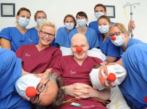 Für ein paar Minuten vergessen, dass man auf der Isolierstation gefangen ist: Louis und seine Mutter Nicola freuen sich über den Besuch der UKM Clinic-Clowns. Pflegerin Lea Preiss (r.) machte die regelmäßigen Visiten der Clowns erst möglich. (Foto: UKM)