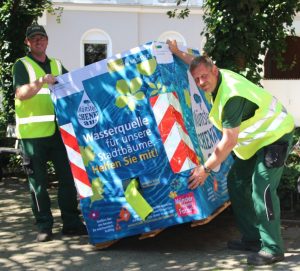 Fabian Böckmann und Bernd Lohmann vom Amt für Grünflächen, Umwelt und Nachhaltigkeit stellen im Hansaviertel einen der 37 Wassercontainer auf. (Foto: Stadt Münster)