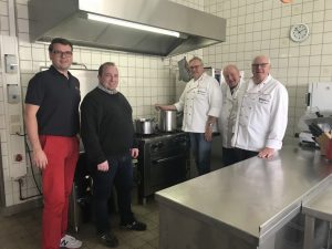 (v.l.): Tobias Jainta (Stadtbeauftragter), Kai Flottmann (Geschäftsführer) und das Küchenteam rund um Bernhard Kuper (v.r.) freuen sich auf den Einsatz. (Foto: Malteser)