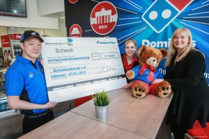 Store-Manager Kris Glaser und Corinna Ulrich (l.) vom Domino’s Marketing übergaben den übergroßen Scheck mit den Spendengeldern an Katja Sonnenstuhl (r.) von Herzenswünsche e.V. (Foto: rwe)