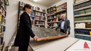Dr. Annik Wüthrich und Prof. Dr. Erhart Graefe müssen das große Buch zu zweit tragen. (Foto: wf / Weber)
