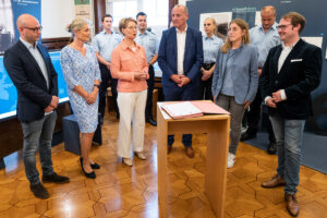 Während der Unterzeichnung (v.l.): Mike Khunger, Vorsitzender der Jüdischen Gemeinde, Bürgermeisterin Angela Stähler, Polizeipräsidentin Alexandra Dorndorf, Christoph Keller, Leiter der HSPV NRW am Standort Münster sowie Stadträtin Cornelia Wilkens und Stefan Querl, Leiter der Villa ten Hompel. (Foto: Stadt Münster/Patrick Schulte)