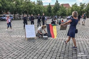 Die "Hygiene-Demos" auf dem Domplatz (hier eine Teilnehmerin mit einer Deutschlandfahne) rufen auch regelmäßig Gegendemonstranten auf den Plan. (Archivbild: Philipp Schröder)