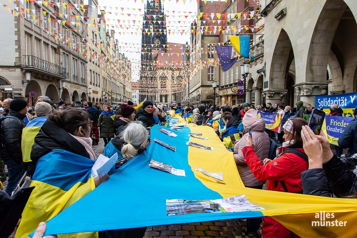 Teilnehmer der Solidaritätskundgebung der Gesellschaft für bedrohte Völker (GfbV) entrollten ein langes Banner. (Foto: Michael Bührke)