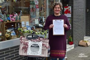 Marion Lohoff-Börger zeigt uns vor ihrem Lädchen an der Wolbecker Straße ihren Antrag, Masematte als UNESCO-Kulturerbe anerkennen zu lassen. (Foto: Tessa-Viola Kloep)